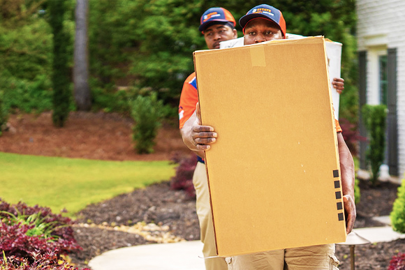 Cheap movers moving boxes into a new house in Marietta